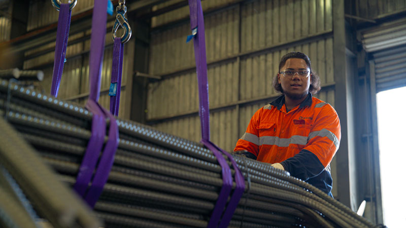 Steel worker loading reinforcing bar